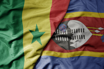 big waving national colorful flag of senegal and national flag of eswatini .