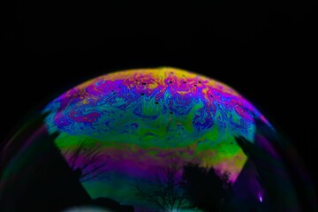Closeup shot of details on a holographic soap bubble in the dark