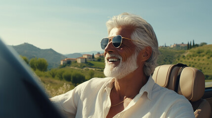 Joyful senior man driving a convertible car in countryside, feeling free and happy