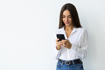 Portrait of a smiling woman holding smartphone over white background