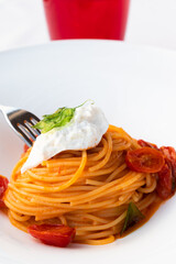Italian pasta - spaghetti with burrata cheese closeup, mediterranean diet.