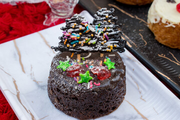 Christmas theme homemade dark chocolate cupcake . Black Forest design with chocolate xmas tree  and sugar sprinkle .