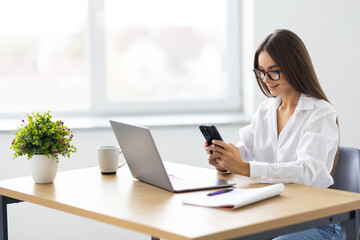 Portrait of attractive positive lady sit chair use phone write typing modern office indoors