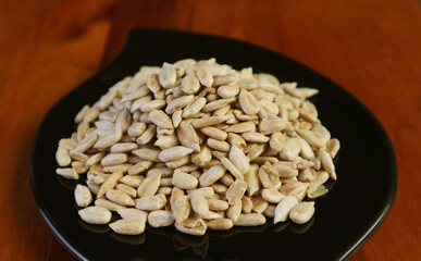 Closeup of roasted sunflower seeds in a black saucer