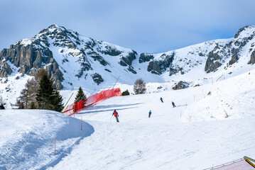 Skiers on a high altitude ski slope in the European Alps on sunny winter day