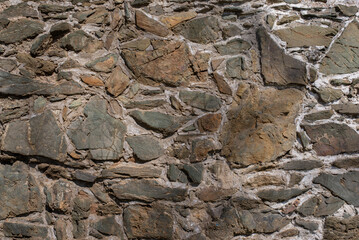 Medieval brick wall close up. Texture background of an old wall made of stone rocks.
