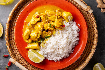 Chicken in curry sauce and rice on gray background top view, Indian food close up