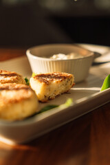 Cheesecakes with sauce on a wooden table under sunlight.