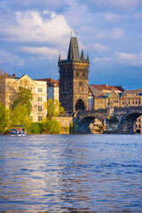 Fototapeta premium Charles Bridge (Karluv Most) on Vltava river and Old Town Bridge Tower, famous tourist destination in Prague, Czech Republic (Czechia), at sunset