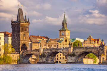Obraz premium Charles Bridge (Karluv Most) on Vltava river and Old Town Bridge Tower, famous tourist destination in Prague, Czech Republic (Czechia), at sunset