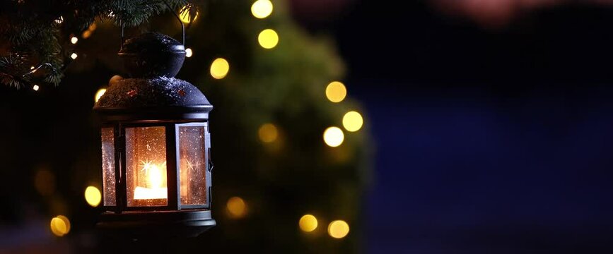 Christmas lantern with a burning candle on the street on a winter evening. Night Decoration