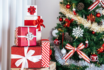 Fototapeta na wymiar Neatly wrapped gift boxes beneath the contemporary Christmas tree in home, Xmas