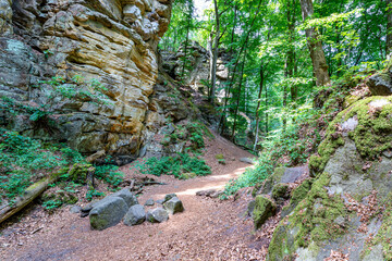 Wooded rocky landscape with hill with hiking trail between rocky slopes or walls of eroded rock...