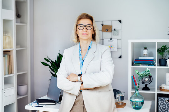 Portrait of smiling 50's stylish, confident mature businesswoman, middle aged company ceo director, experienced senior female professional, business coach team leader in modern office. Female leader