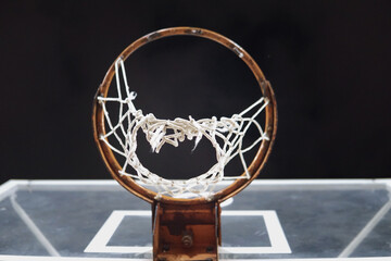 Fototapeta na wymiar Basketball hoop with broken net - detail from below - night scene of playground exterior