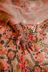 Mehndi master drawing henna tattoo on female