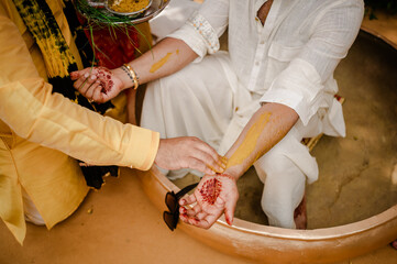 Mehndi master drawing henna tattoo on female