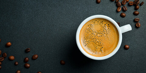 A cup of fragrant arabica or robusta coffee. Espresso. Top view, on a black background. Natural coffee.