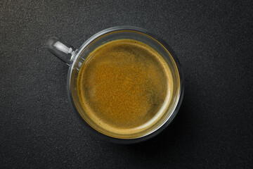 Glass Cup of Espresso coffee. Top view, on a black background, free copy space. Natural coffee.