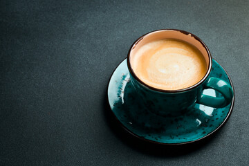 A cup of cappuccino and coffee beans. Top view, on a black background, free copy space. Robusta or Arabica.
