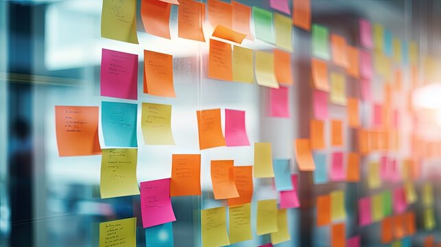 Blur color notes or sticky note on the glass wall in the office during brainstorming session in ideation workshop of design thinking