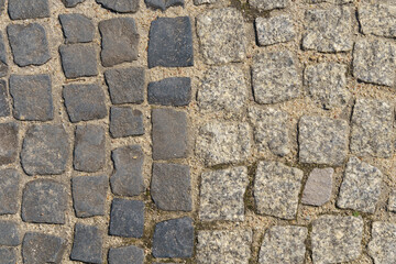 The road is paved with square granite stones.