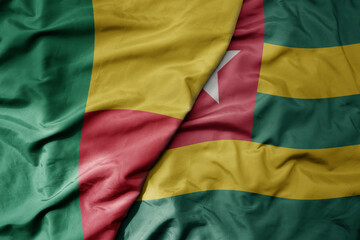 big waving national colorful flag of benin and national flag of togo .