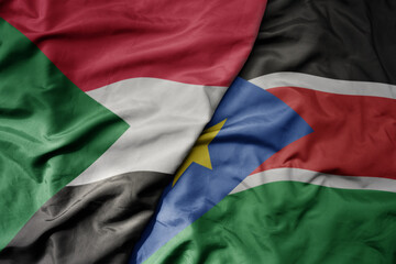 big waving national colorful flag of sudan and national flag of south sudan .