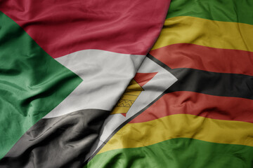 big waving national colorful flag of sudan and national flag of zimbabwe .