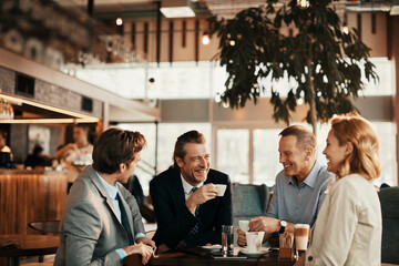 Colleagues Enjoying a Laugh During a Coffee Meeting