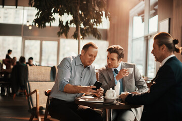 Businessmen Engaged in Discussion Over Coffee