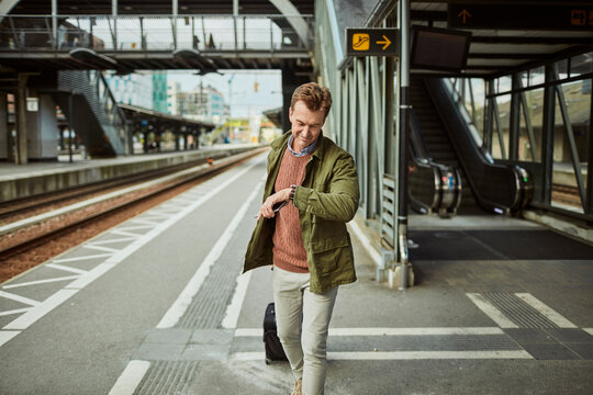 Traveler Checking Time at Train Station Platform