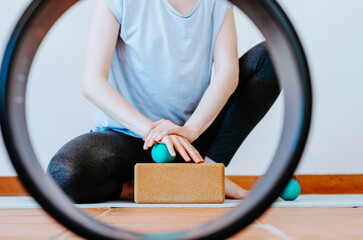 Woman doing palmar fascia release with a therapy ball on a cork block	