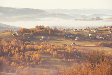 Krajobraz jesienny w Beskidach. Mgliste góry o świcie. Relaks, wypoczynek i pastelowy wschód słońca.