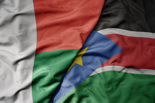 big waving national colorful flag of madagascar and national flag of south sudan .