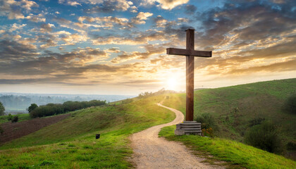 wooden cross of jesus christ faith religion standing on a hill during sunrise cloudy sky with a...