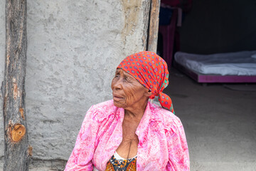 old african woman in front of her house in the village - obrazy, fototapety, plakaty