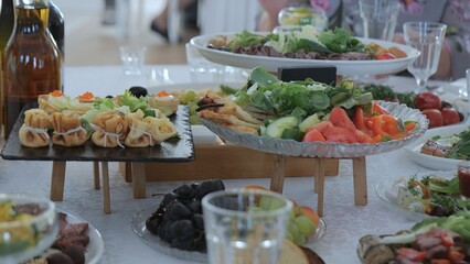 Snack table. Canape with vegetables and cheese, Served table with food. Lots of snacks on the holiday table. Banquet with snacks, cheese and fruits, canapes, salads, appetizers on the festive table.
