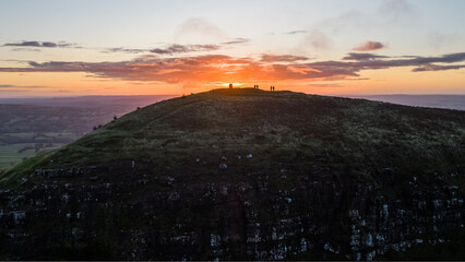 The sun rises over the Skirrid Fawr mountain near Abergavenny in the Brecon Beacons Black Mountains national park. morning walkers enjoy rugged natural beauty in Bannau Brycheiniog South Wales - 679348872