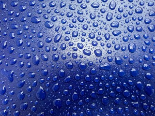 Den Haag, Netherlands - July 25 2021: water drops are laying on the roof of a freshly painted blue car - obrazy, fototapety, plakaty