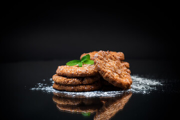 cooked sweet oatmeal cookies on black background