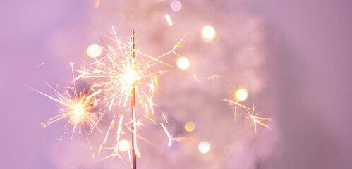 Beautiful sparkles from sparklers on the background of New Year's bokeh, Christmas mood, glitter,...