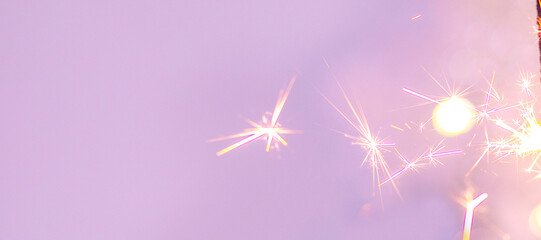 Beautiful sparkles from sparklers on the background of New Year's bokeh, Christmas mood, glitter, festive background.