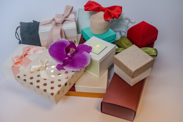 Small gifts lie a white background. Beautiful gift paper and colorful gift bows