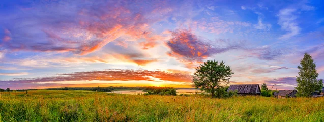 Foto op Canvas Panoramic view on sunset over old wooden hut and lonely tree in countryside © sborisov