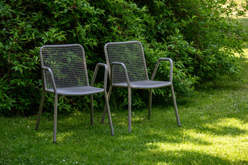 Metal chairs in spring garden. Metal garden furniture for picnics and birdwatching