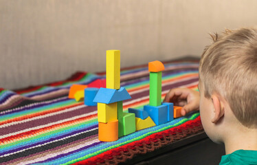 game colored geometric shapes children close-up on the table and the child plays selective focus