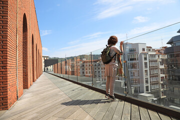 mujer turista asomada a un edificio de bilbao bilbo 4M0A6749-as23