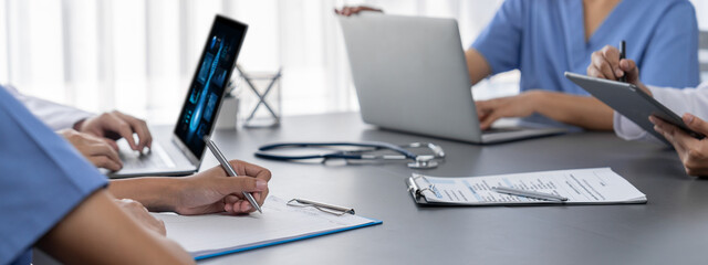 Doctor and nurse in medical meeting discussing strategic medical treatment plan together with report and laptop. Medical school workshop training concept in panoramic banner. Neoteric - Powered by Adobe