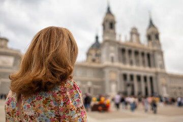 Tourist woman looking at the imposing facade of the Almudena Cathedral in Madrid.